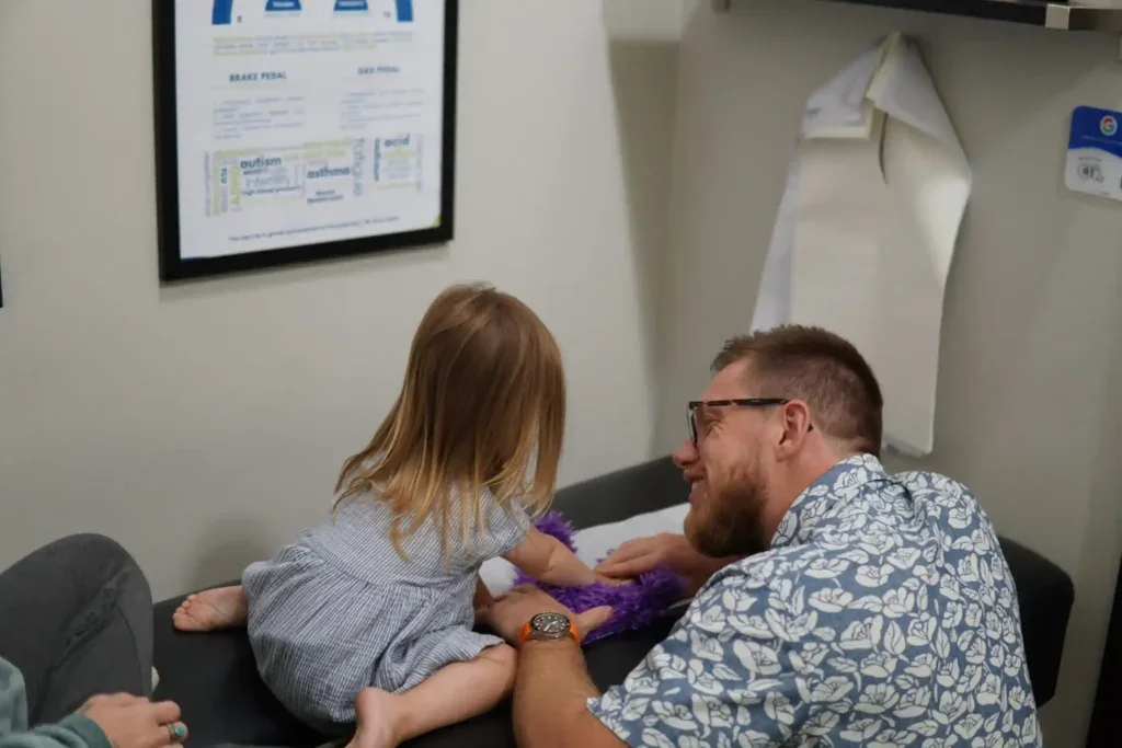 Dr. Pellegrino leaning in toward a young child.
